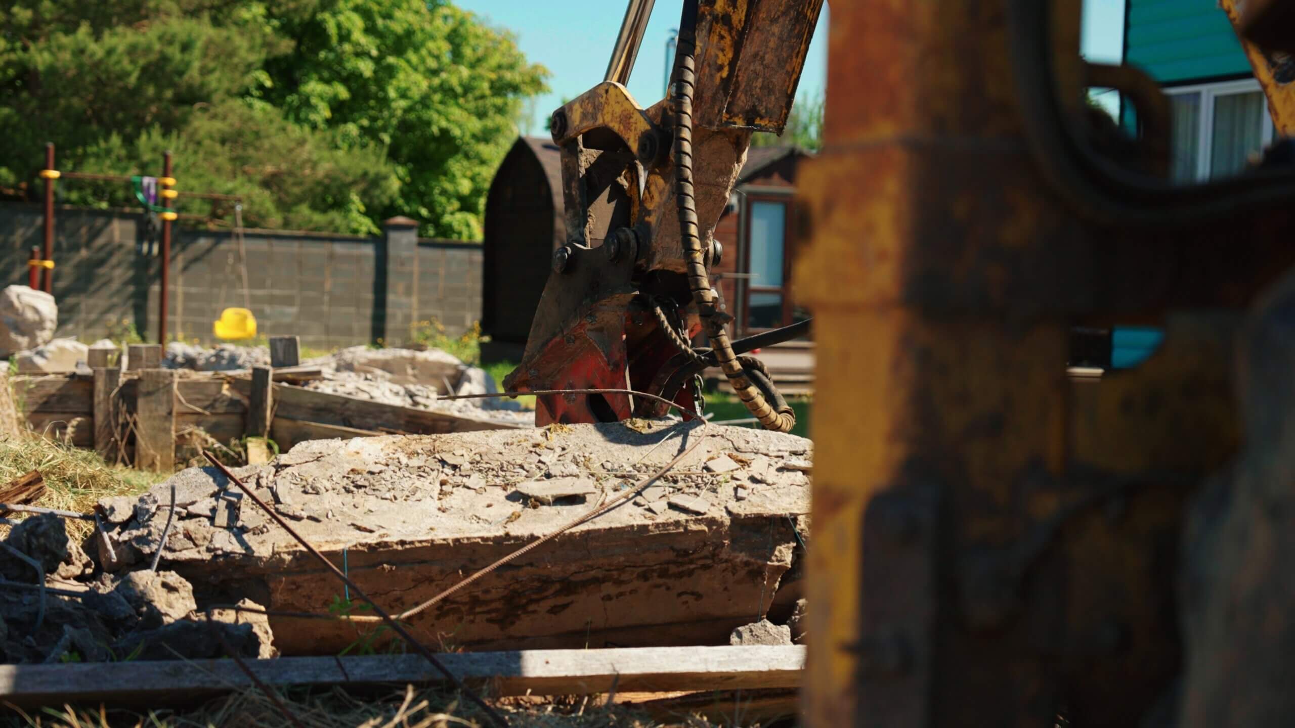 Excavator breaking up a concrete slab during demolition
